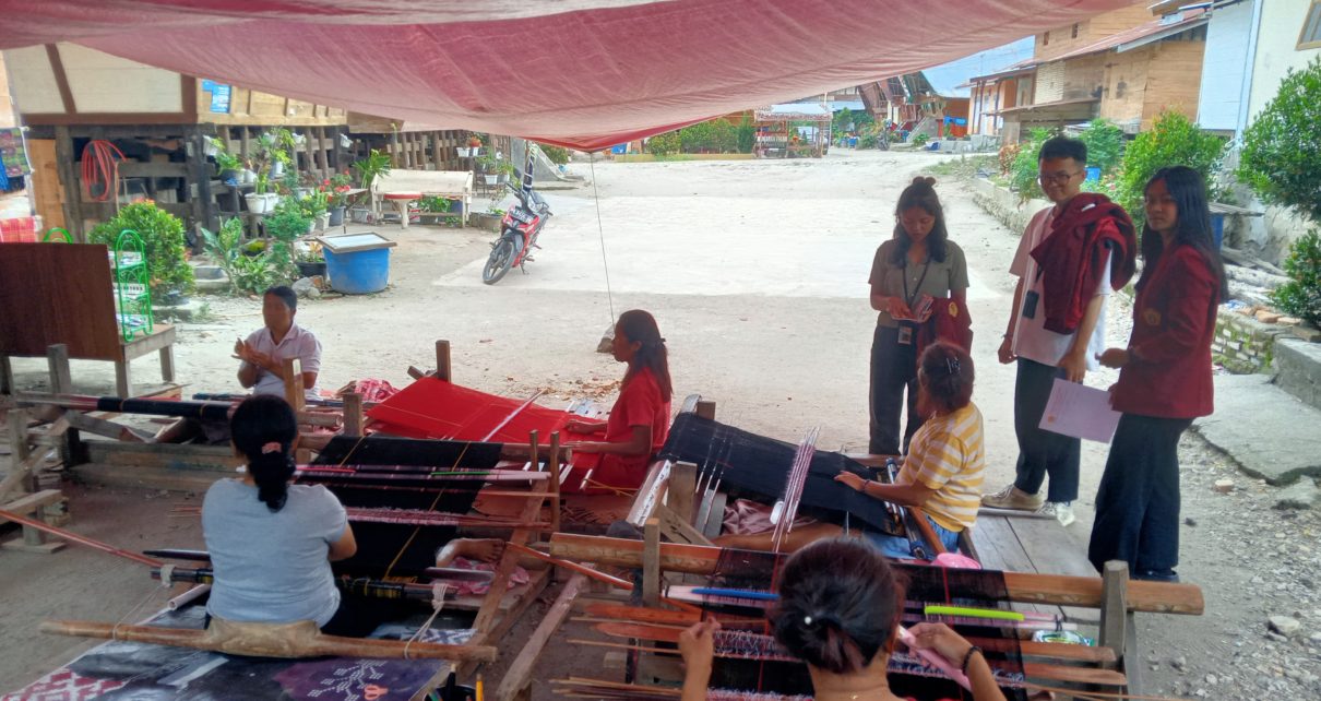 Mahasiswa mengamati para penenun ulos